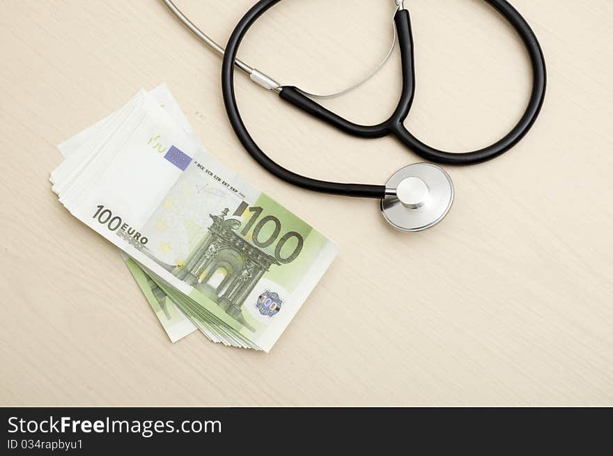 Many Euro bank notes with a stethoscope. Health costs.