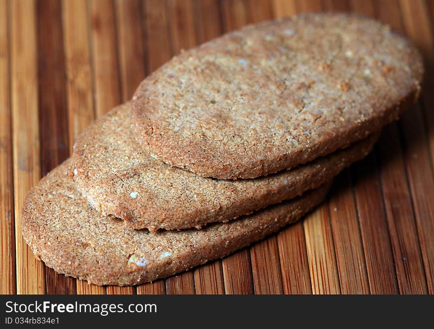 Macro shot of whole wheat biscuits over wooden background.