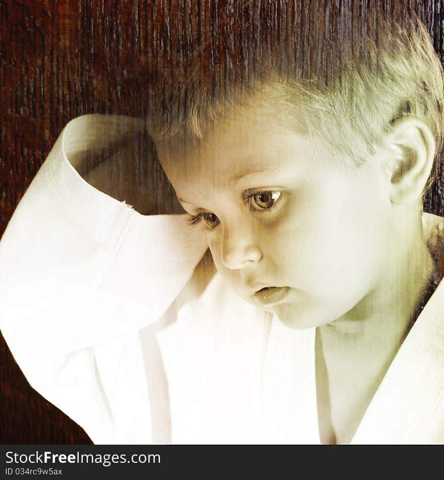 Young boy wearing his karate uniform on a black background. All images used, property of photographer. Young boy wearing his karate uniform on a black background. All images used, property of photographer