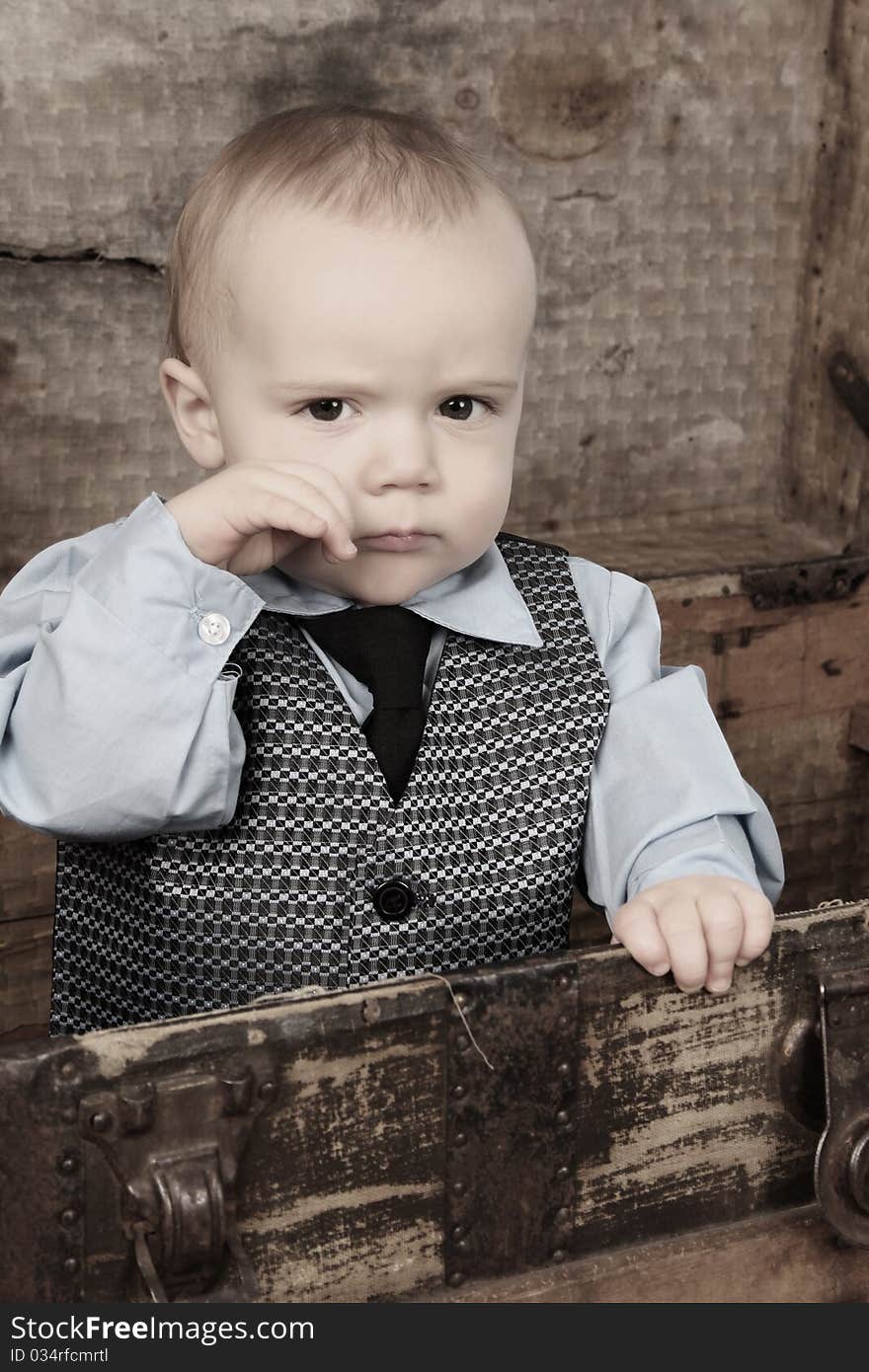 Baby boy playing inside an antique trunk. Baby boy playing inside an antique trunk