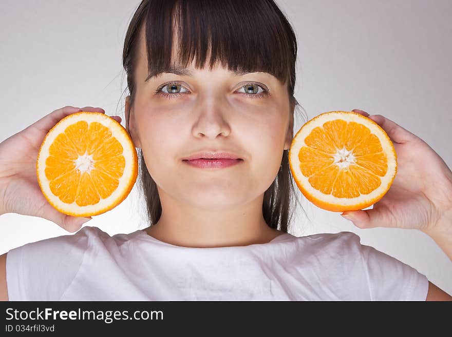 Attractive caucasion girl with two oranges in hands. Artistic selective focus. Attractive caucasion girl with two oranges in hands. Artistic selective focus.