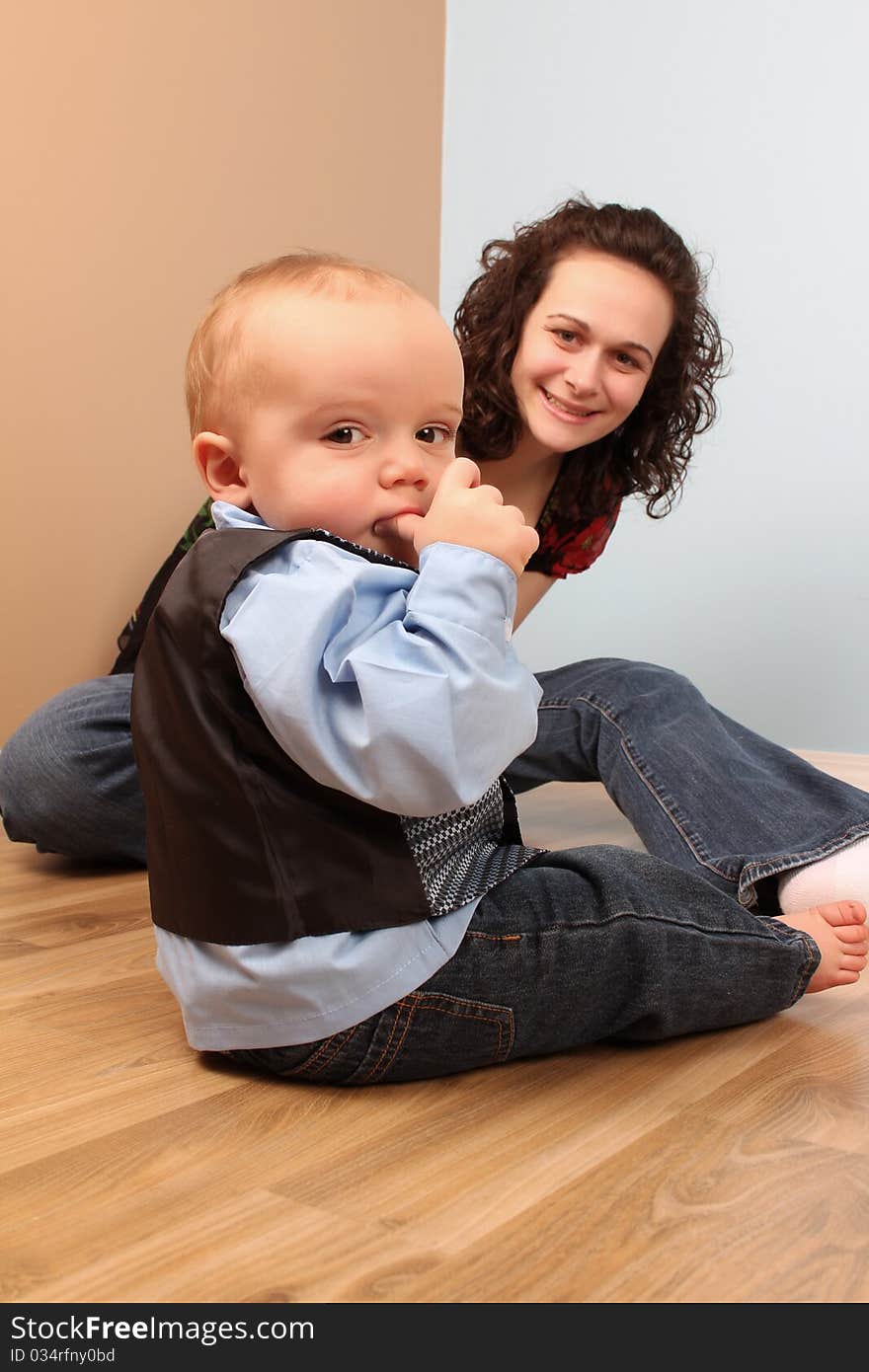 Mother and son playing indoors on a wooden floor