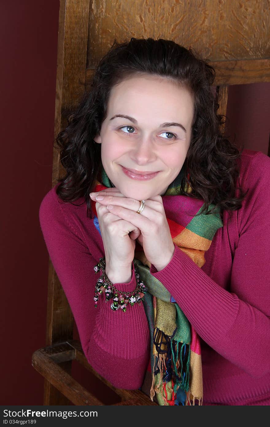 Brunette female wearing a pink top and colorful scarf