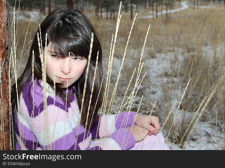 Young brunette teen playing in the field after the snowfall. Young brunette teen playing in the field after the snowfall