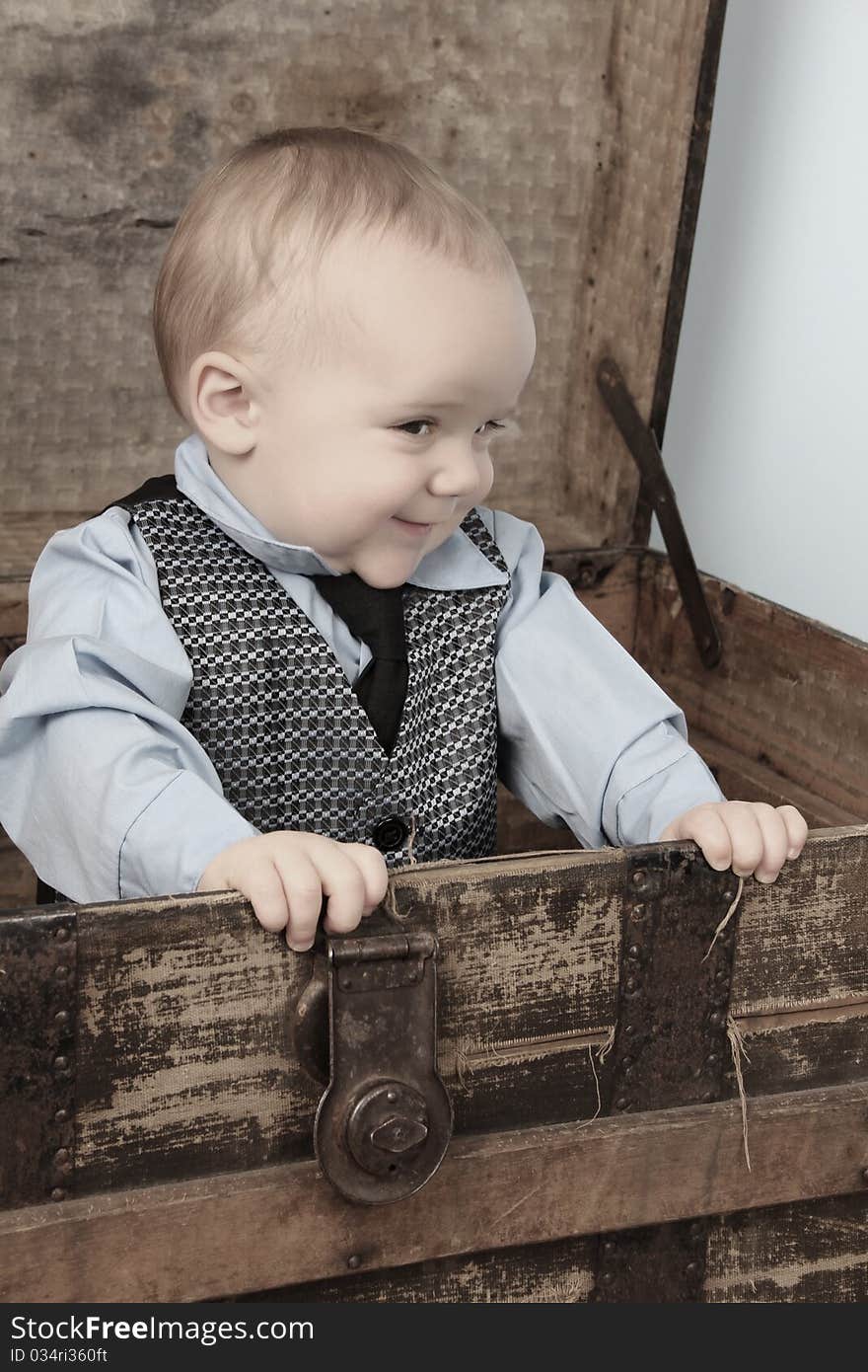 Baby boy playing inside an antique trunk. Baby boy playing inside an antique trunk