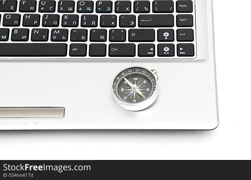 Compass on the laptop keyboard isolated on a white background
