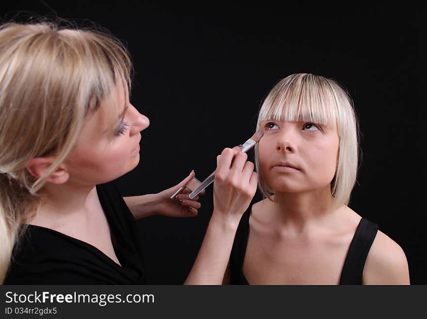 Stylist, cosmetologist doing make-up face with a brush. Stylist, cosmetologist doing make-up face with a brush