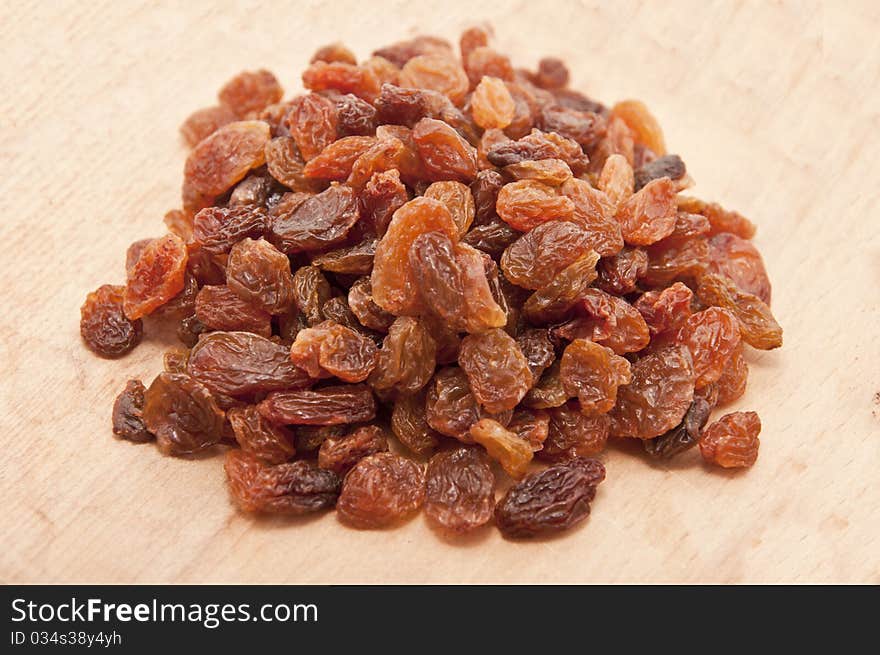 Dried grapes on wooden plate