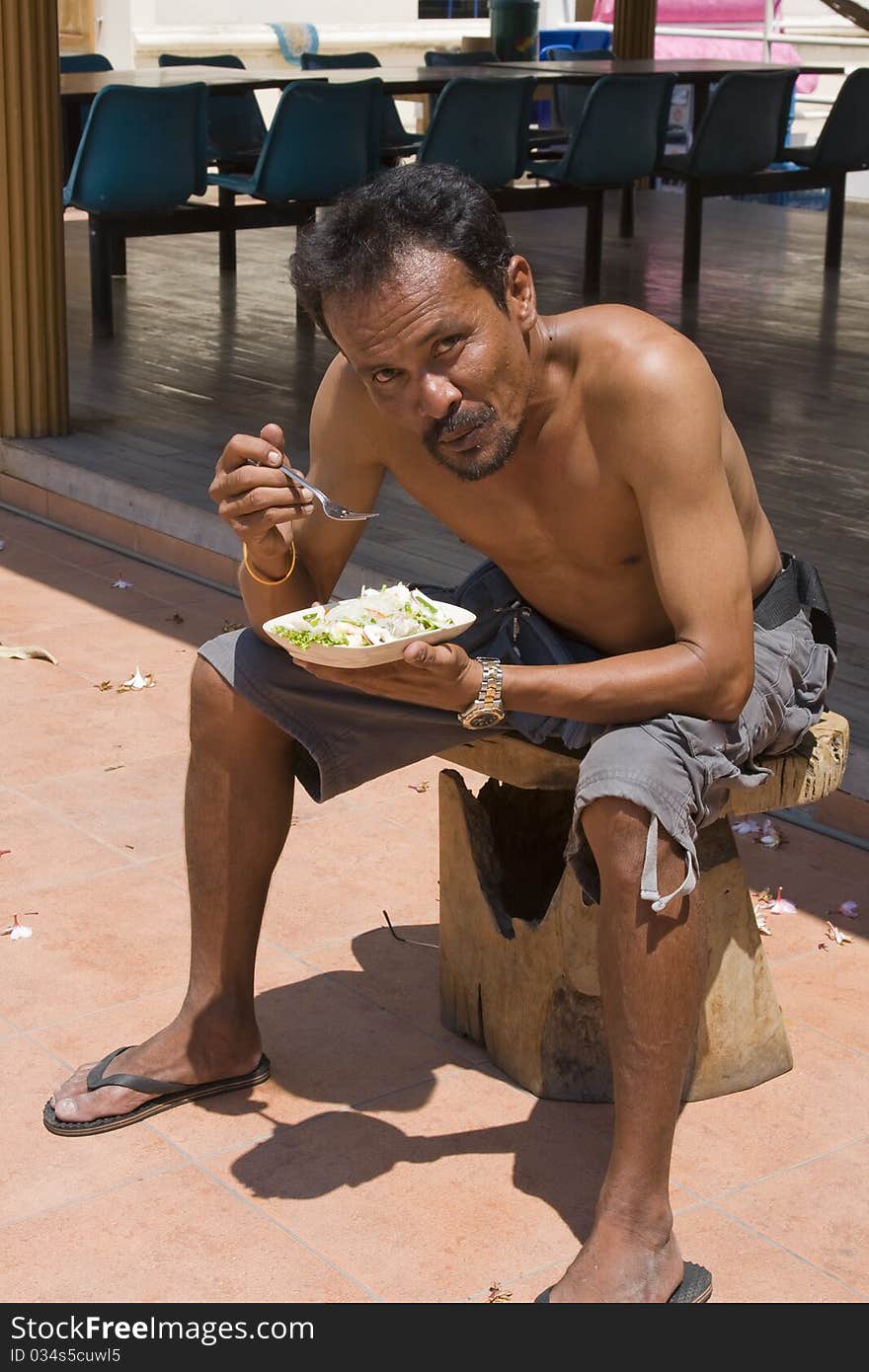 Thai man eats . Summer, sunny day .