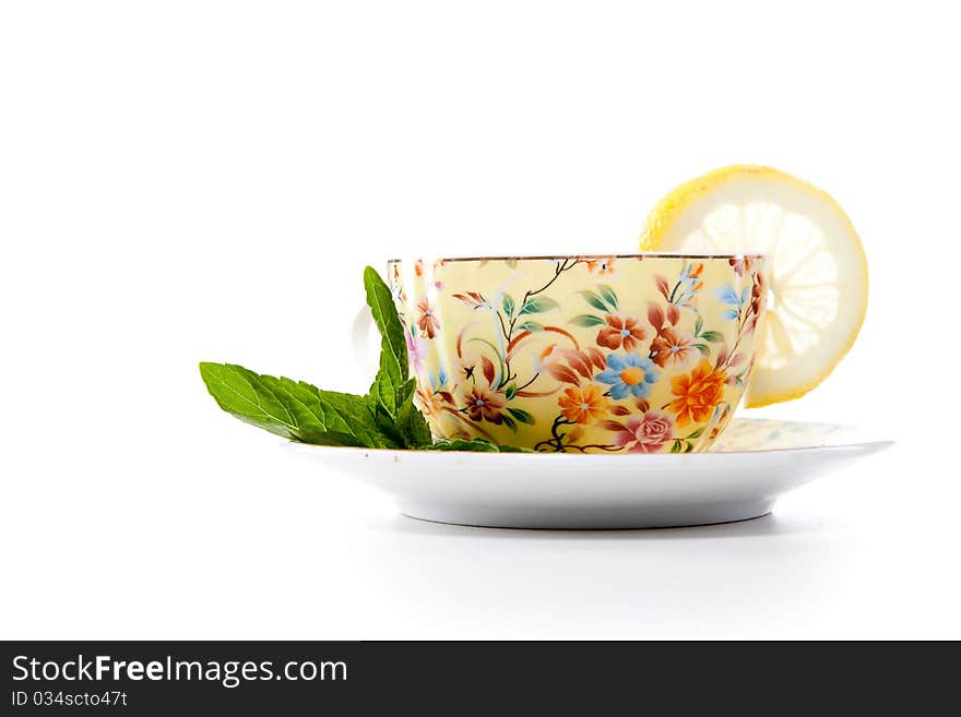 Cup of fresh tea with mint leaves and lemon