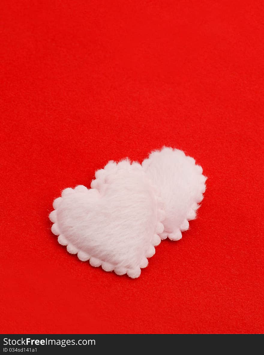 Two fluffy hearts on a red background