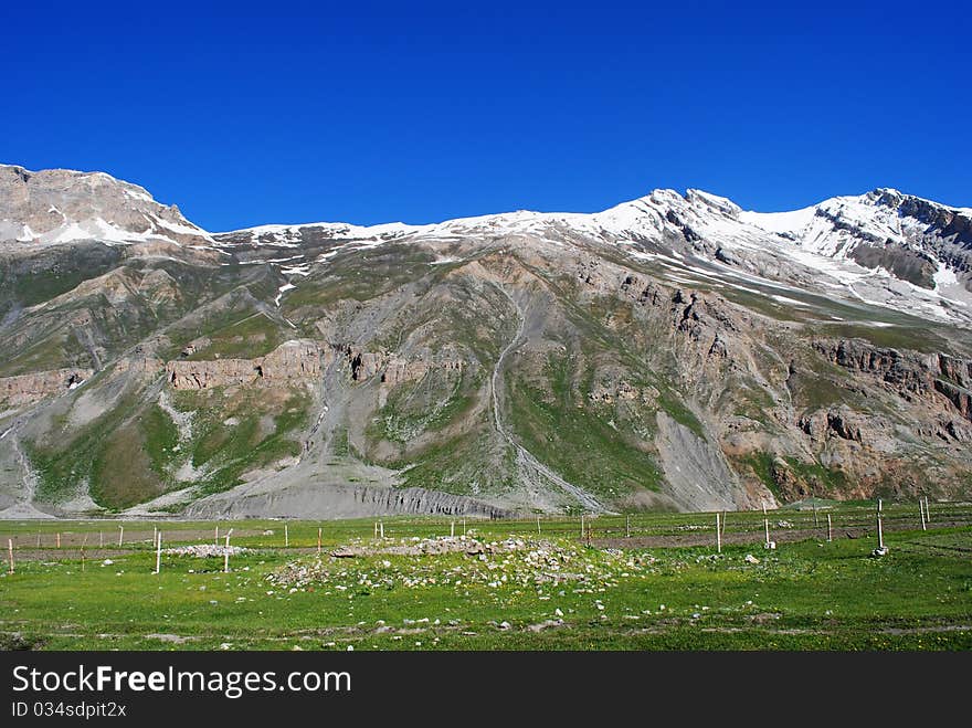 A beautiful landscape scene with vibrant greenery and snow-peak. A beautiful landscape scene with vibrant greenery and snow-peak.