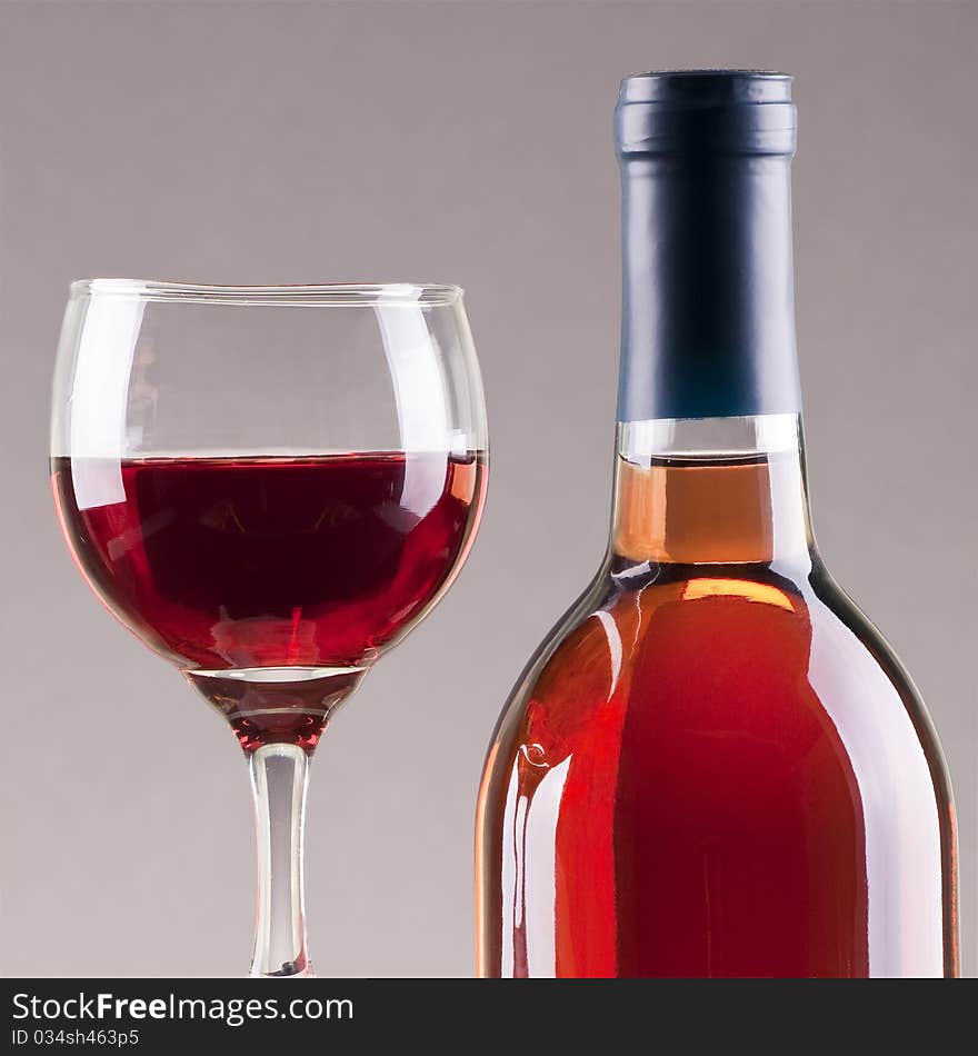 Glass and bottle of rose wine  with gray background