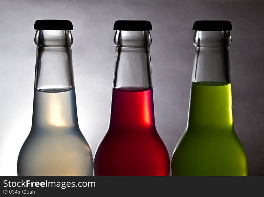 Three colorful bottle of drink on light background