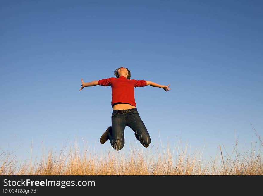 Jumping woman on a sunny day against a blue sky