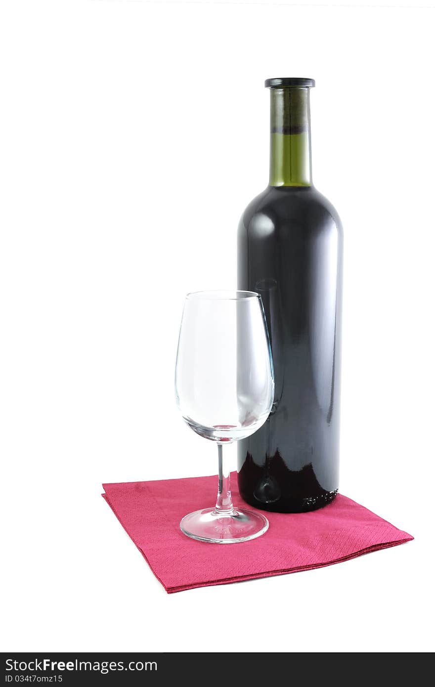 Bottle of red wine and an empty glass on the serviette isolated on white. Bottle of red wine and an empty glass on the serviette isolated on white