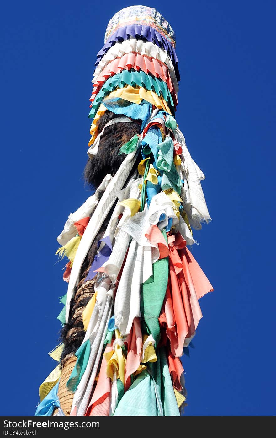 A polar wrapped up with prayer flags in Lhasa,Tibet,with blue sky as background. A polar wrapped up with prayer flags in Lhasa,Tibet,with blue sky as background