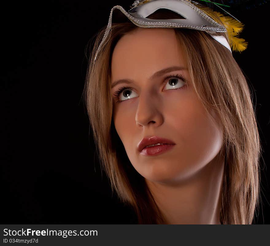 Young woman actor face with mask on black background