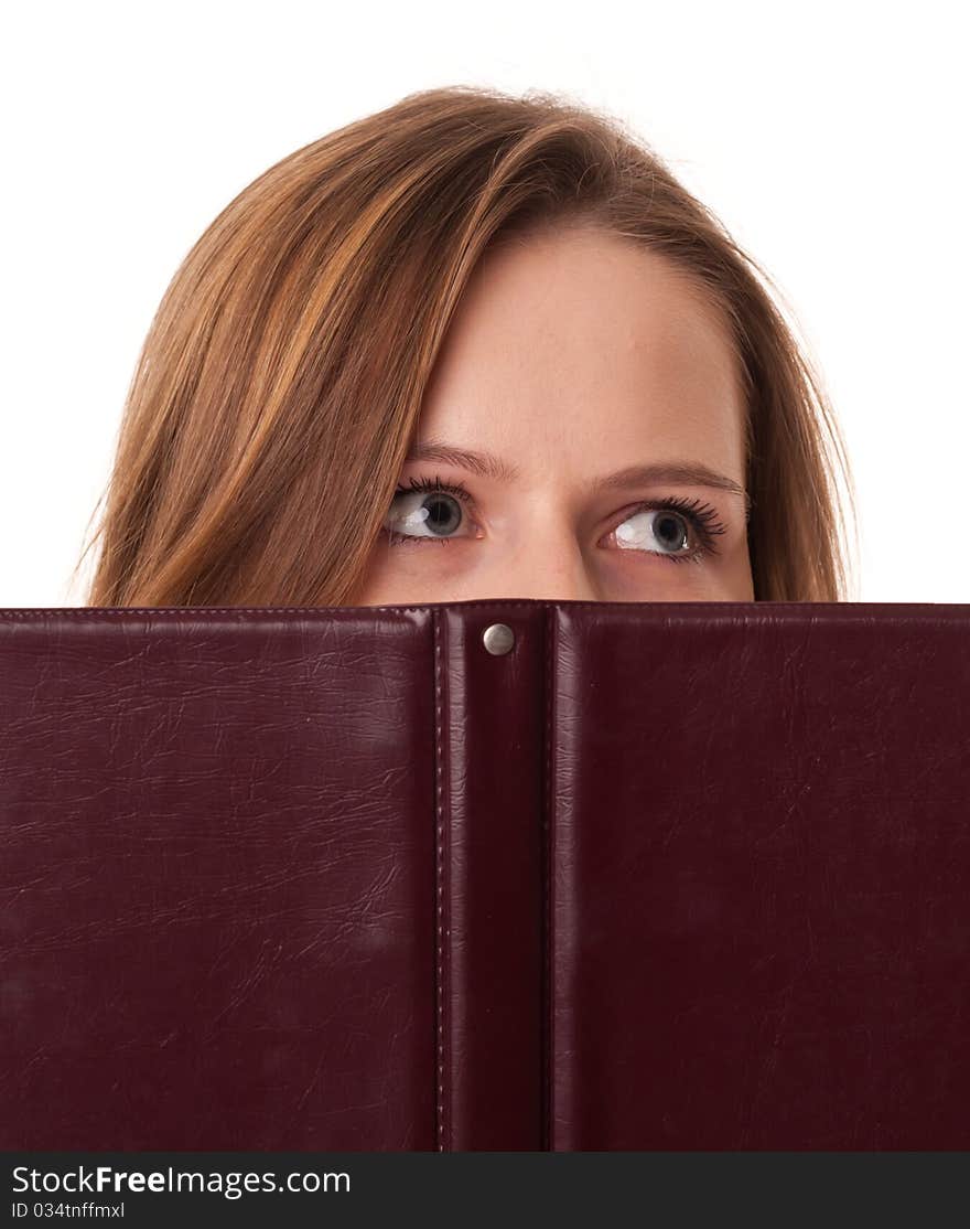 Young woman hides her mouth behind the book on white background