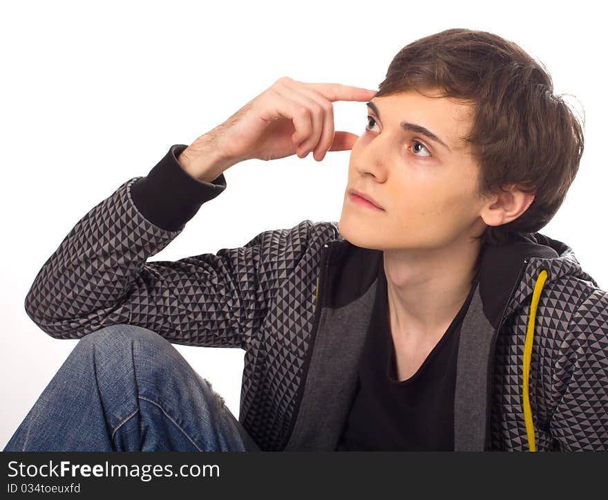 Handsome young man sitting and thinking on white background