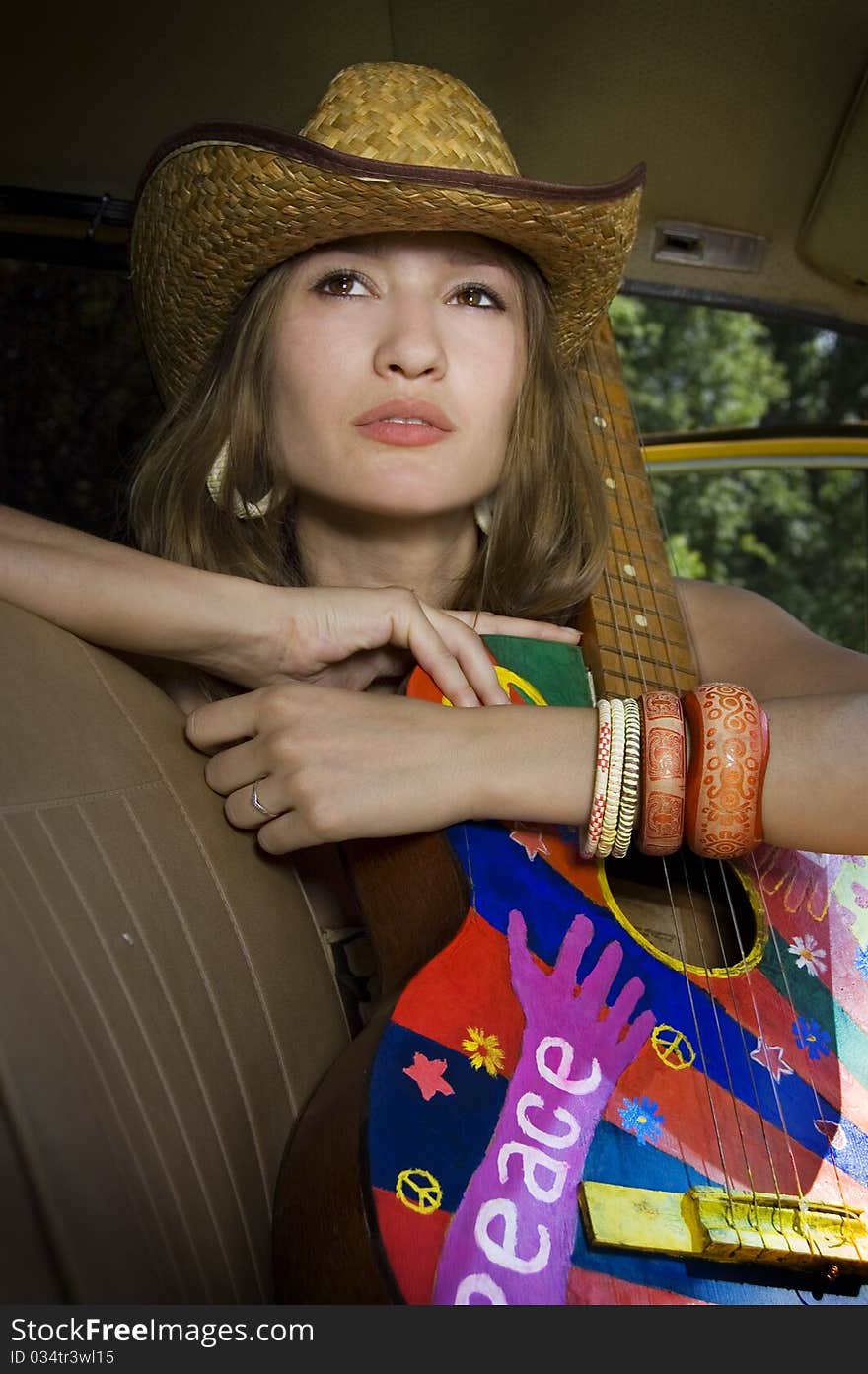 Girl sitting in the car with a guitar