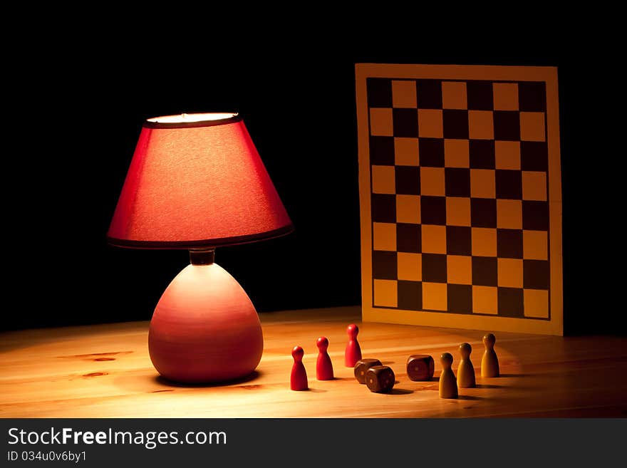 Lamp illuminating dice game on wooden table