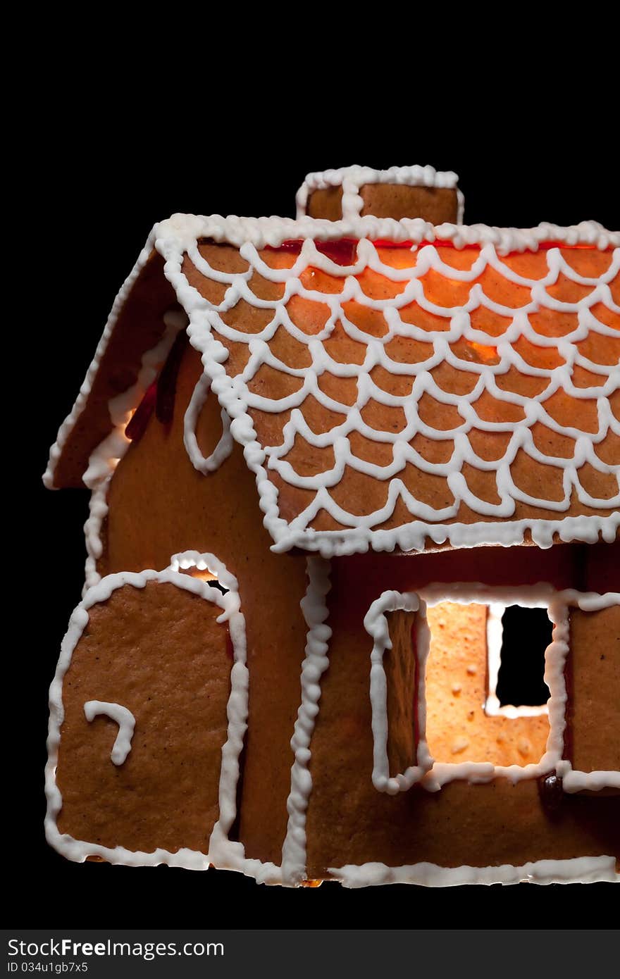 Illuminated christmas gingernut house on black isolated background