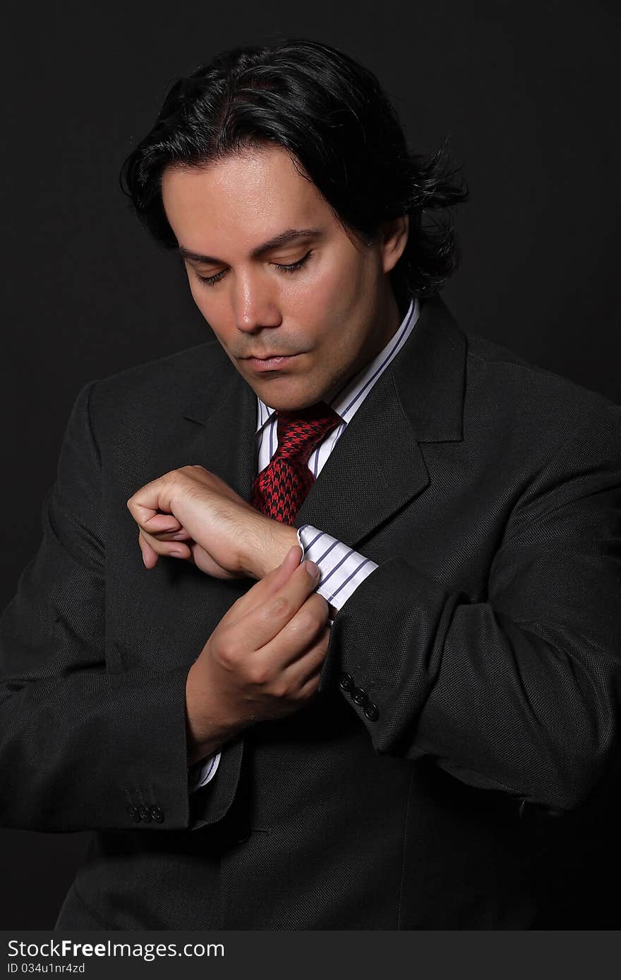 Businessman buttoning his shirt in a studio