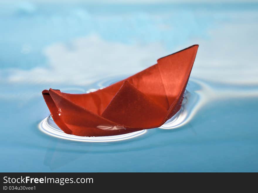 Red paper boat on blue water. Red paper boat on blue water