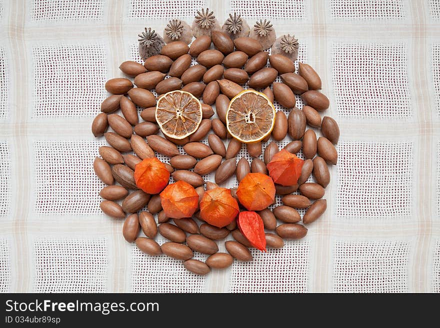 Emoticon face made from dry fruits, nuts and ground-cherry flowers.