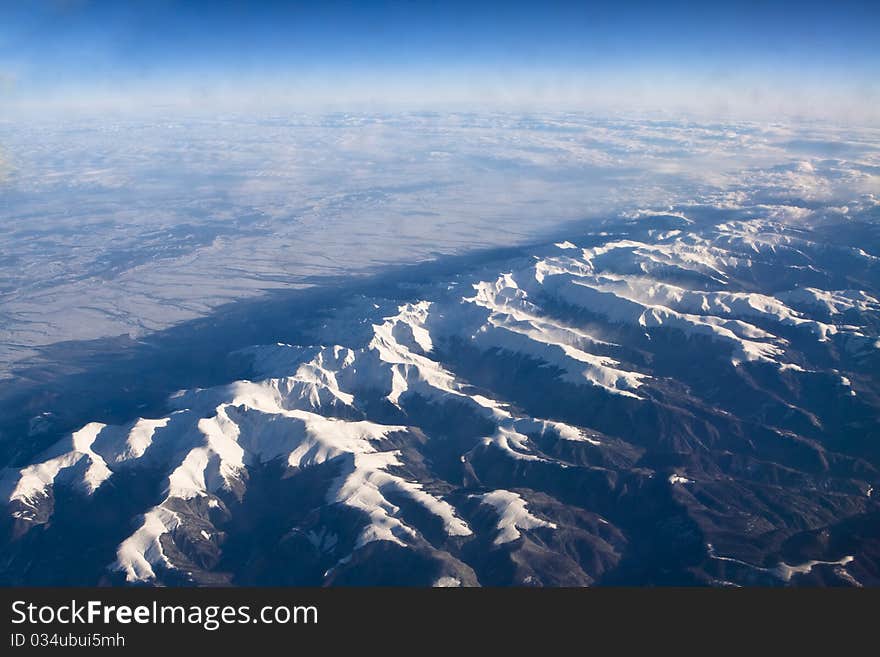 Rocky mountains covered with snow aerial view from airplane