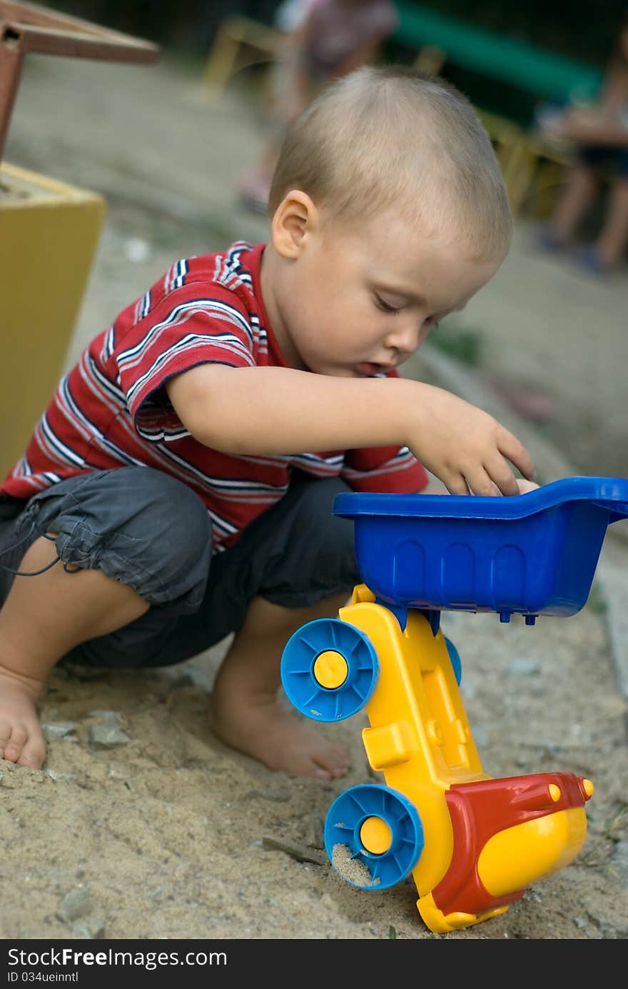 A little boy playing with a car