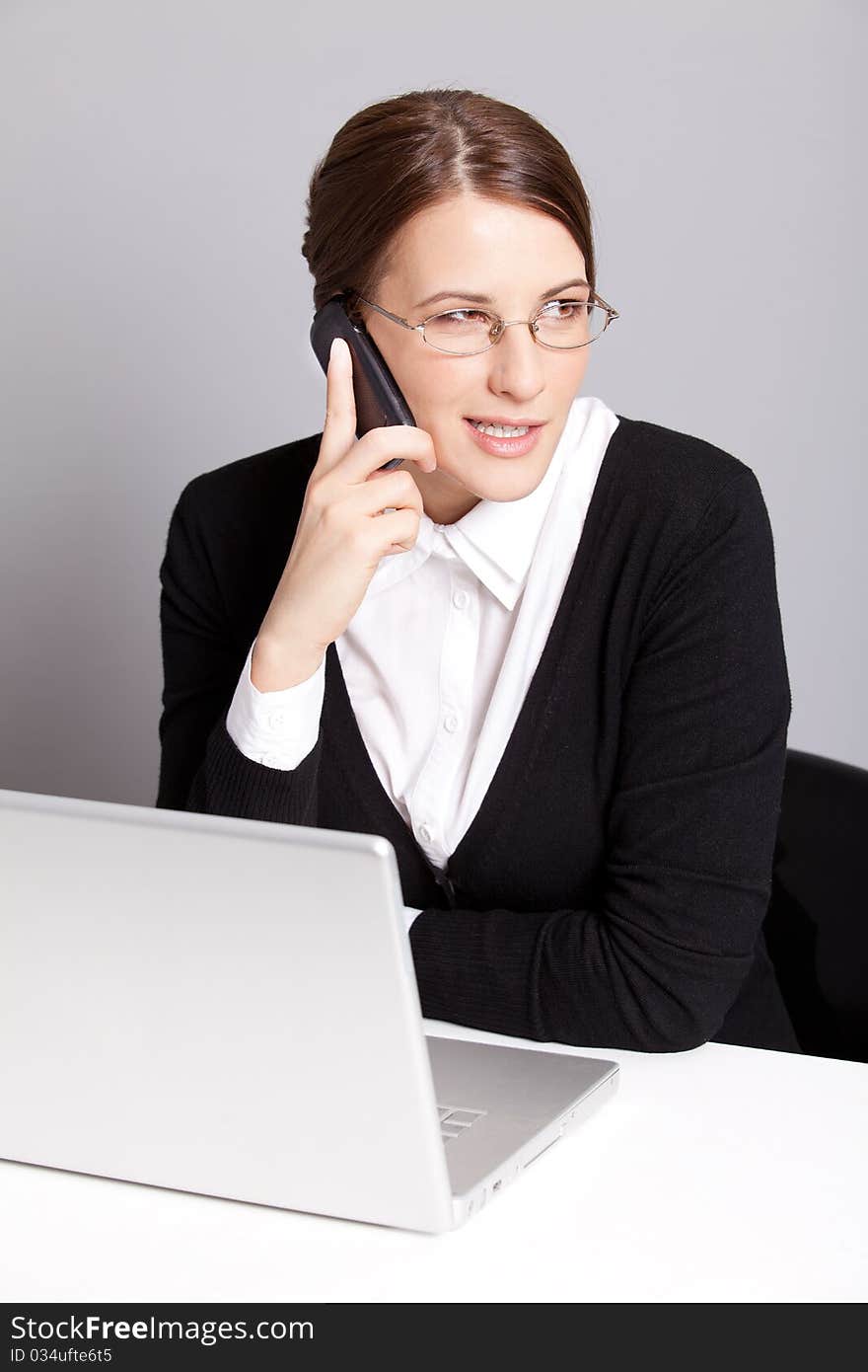 Young business woman talking by the phone. Young business woman talking by the phone