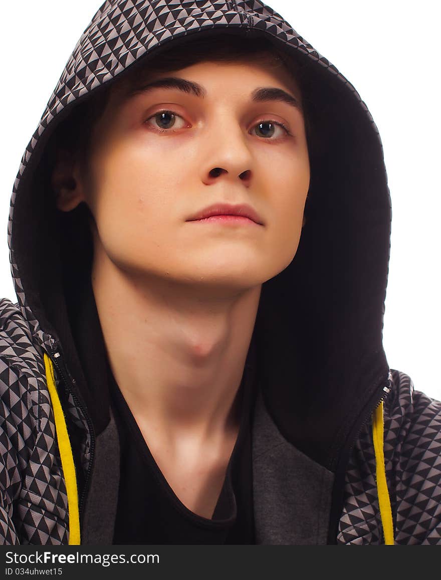 Serious young man standing and looking at you head covered with hood on white background