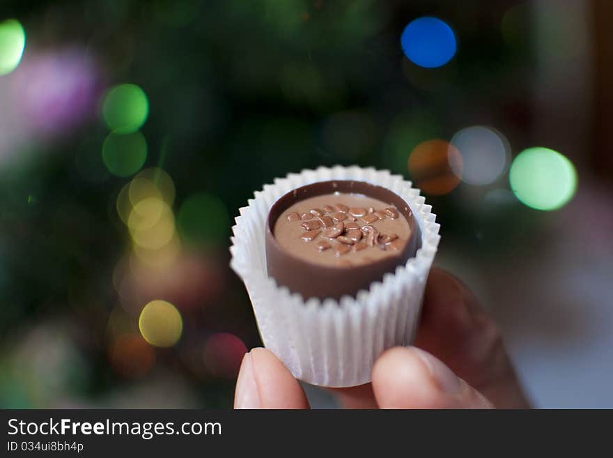 Chocolate candy filled with Christmas lights on the background. Chocolate candy filled with Christmas lights on the background