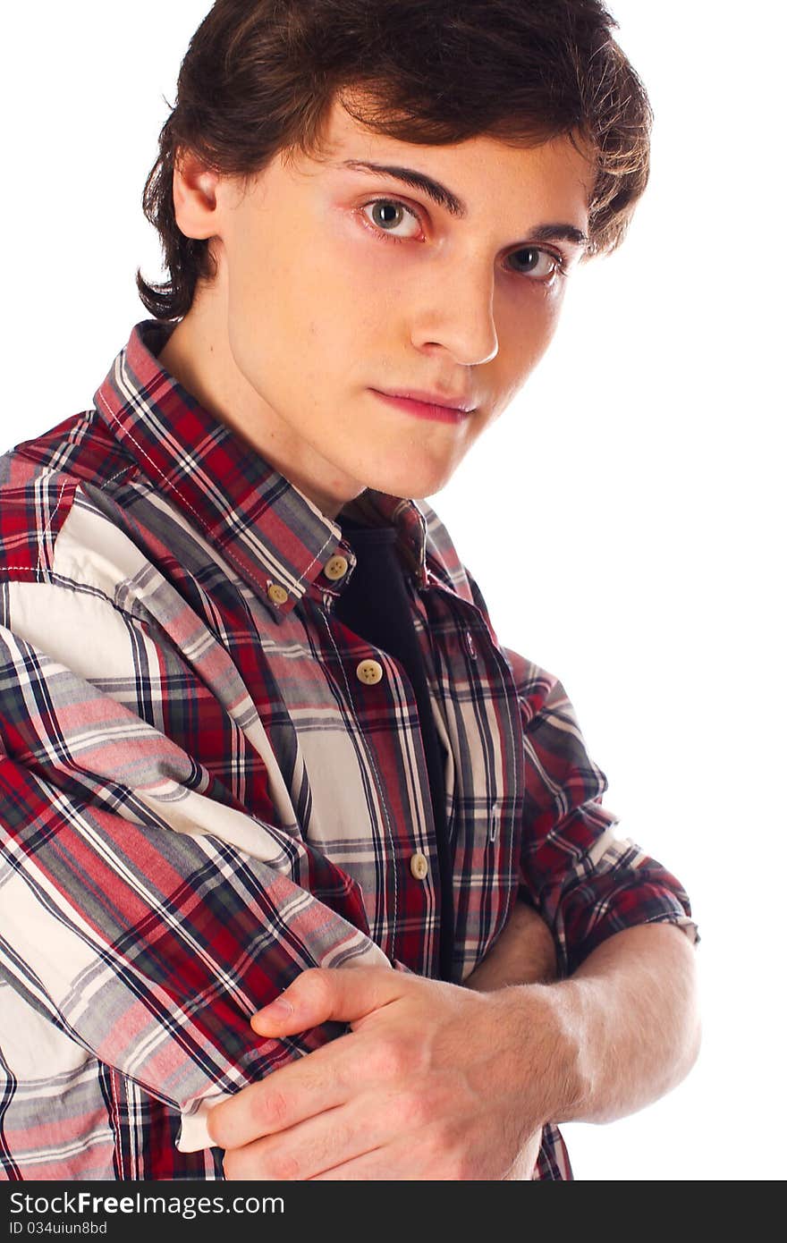 Serious young man standing and looking at camera with hands folded