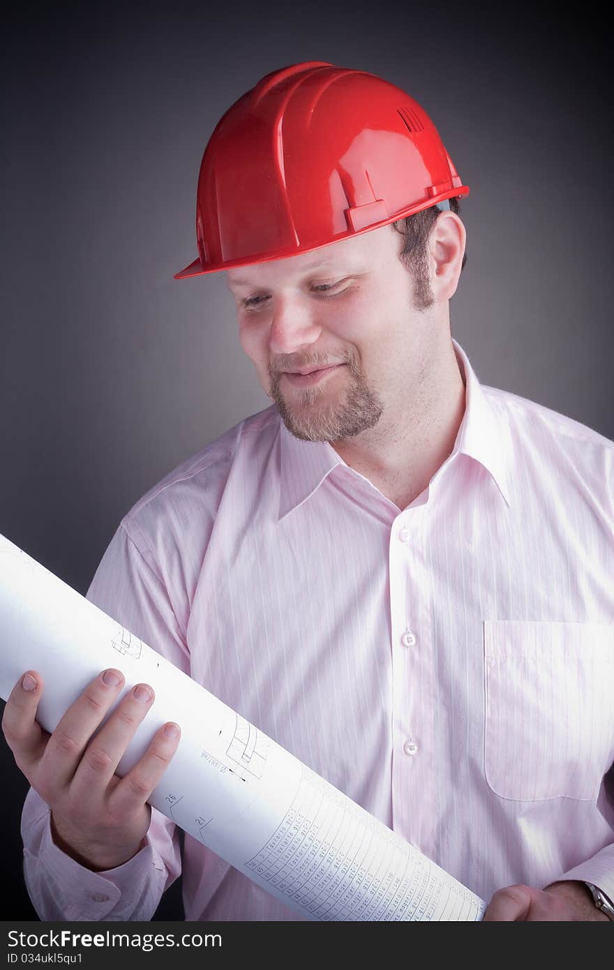 Young attractive engineer with blueprints, smiling