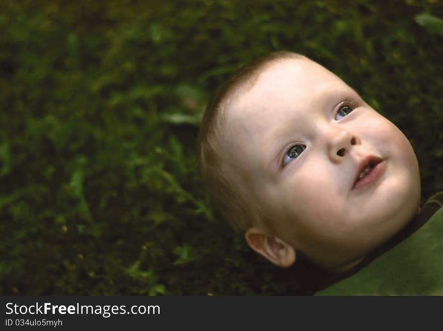 A little boy lying on grass