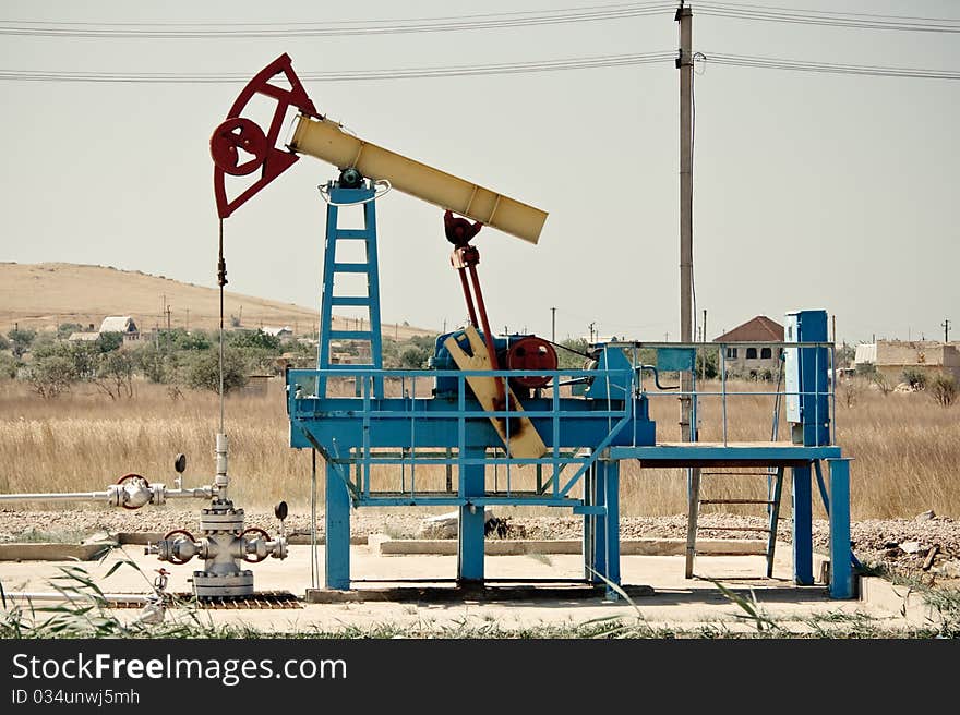 An oil pump jack against clean sky.