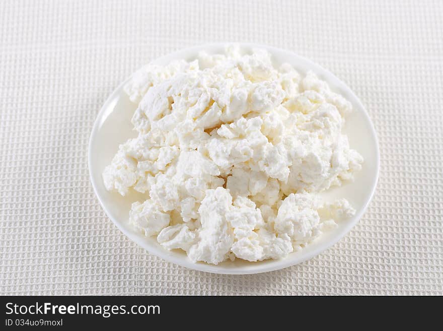 Fresh cottage cheese on the white plate