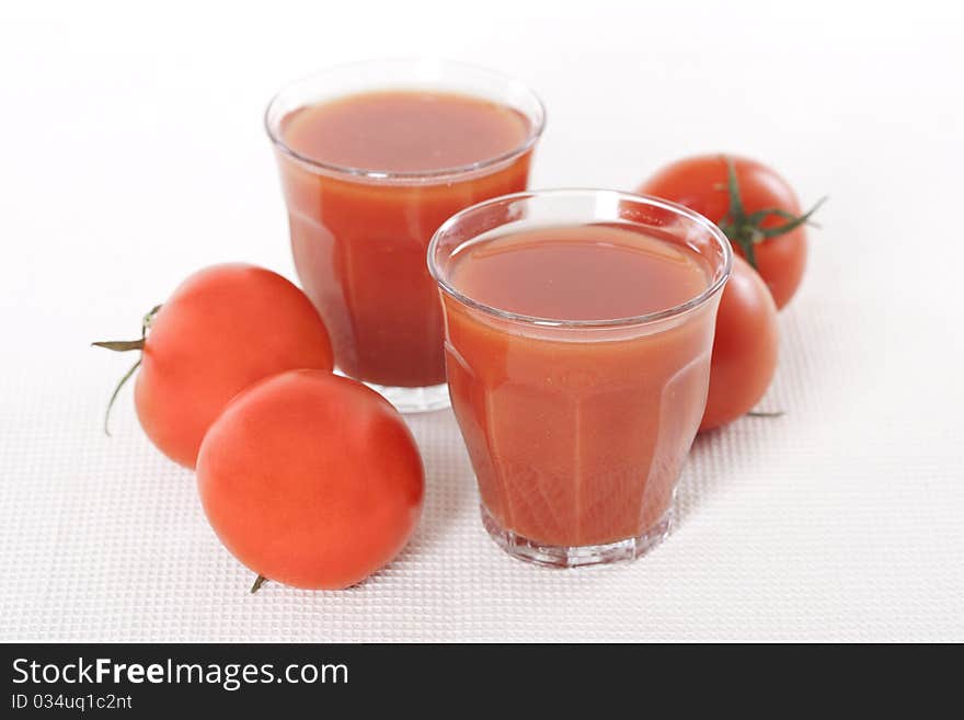 Fresh tomatoes and two glasses full of tomato juice. Fresh tomatoes and two glasses full of tomato juice