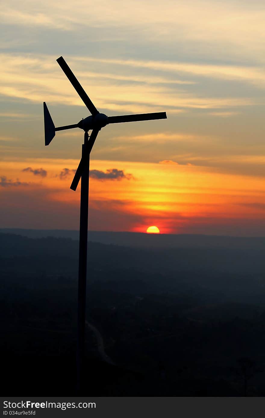 Wind turbine over sunset background