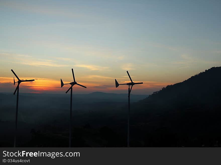 Wind turbine over sunset background