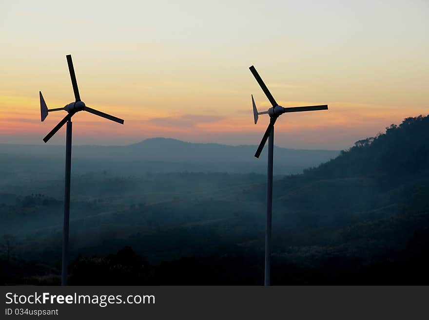 Wind turbine over sunset background