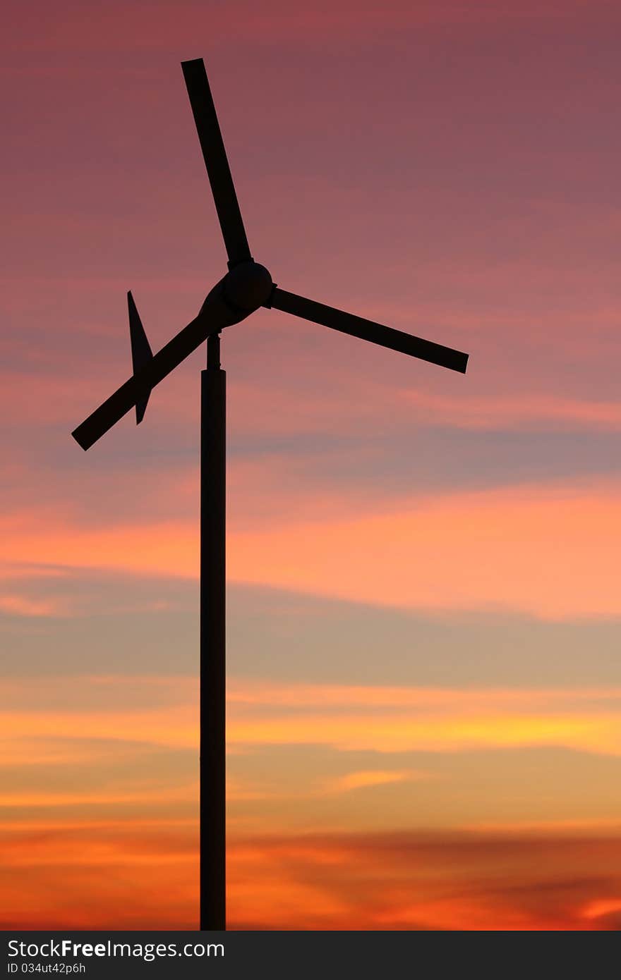 Wind turbine over sunset background