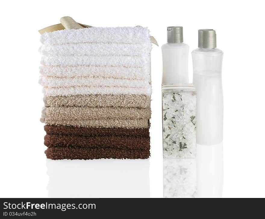 Stack of fresh wash cloths and bath products on a white reflective surface. Stack of fresh wash cloths and bath products on a white reflective surface