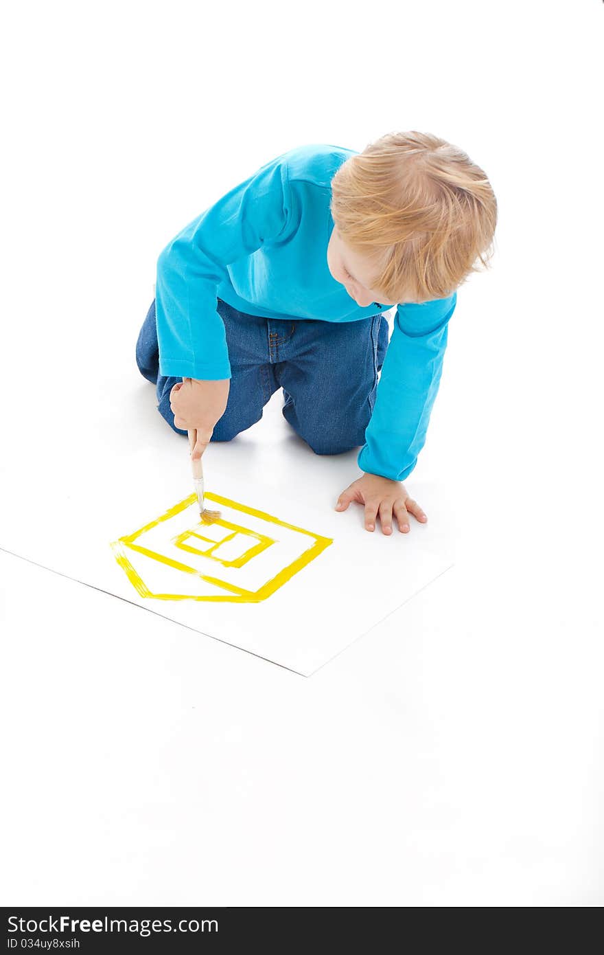 Little boy drawing a small house on a paper. Little boy drawing a small house on a paper