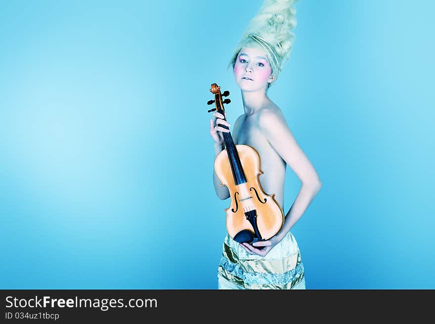 Portrait of an artistic young woman posing with violin. Shot in a studio. Portrait of an artistic young woman posing with violin. Shot in a studio.