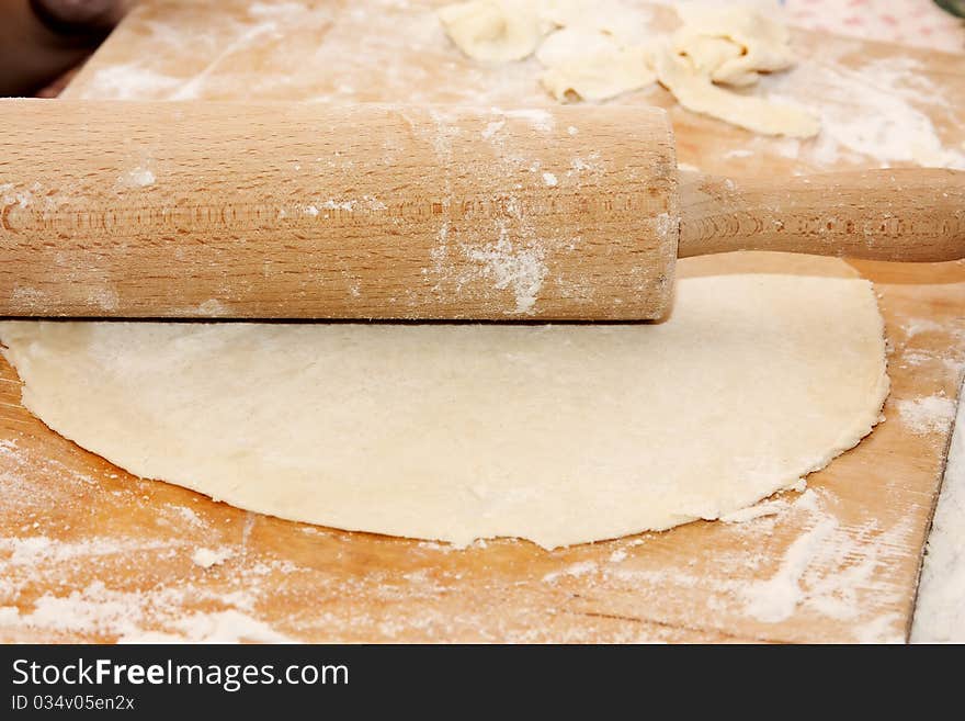 Thin layer of raw dough on wood background
