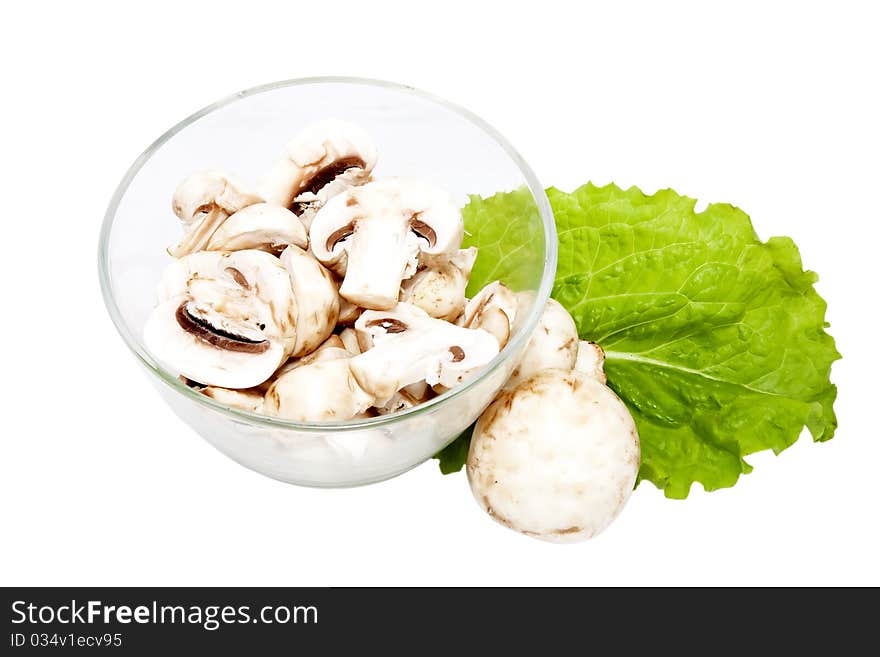 Mushrooms, sliced into pieces, in a glass bowl. Mushrooms, sliced into pieces, in a glass bowl